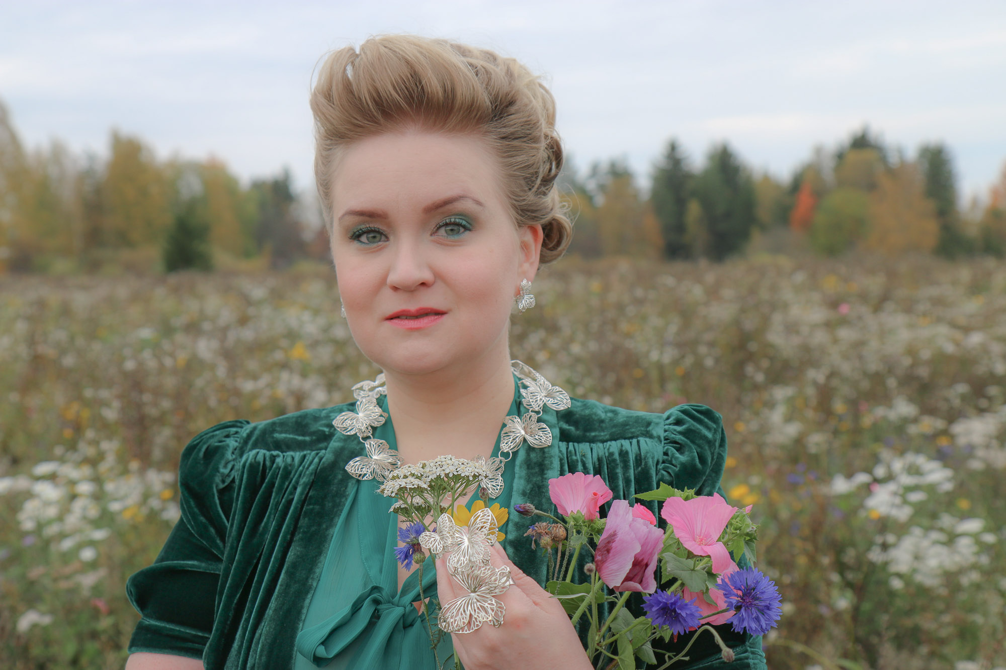 Jenni Rutonen Kesän Siivekäs -korusarjan kääyty ja sormus kuvattuna kukkaniityllä.