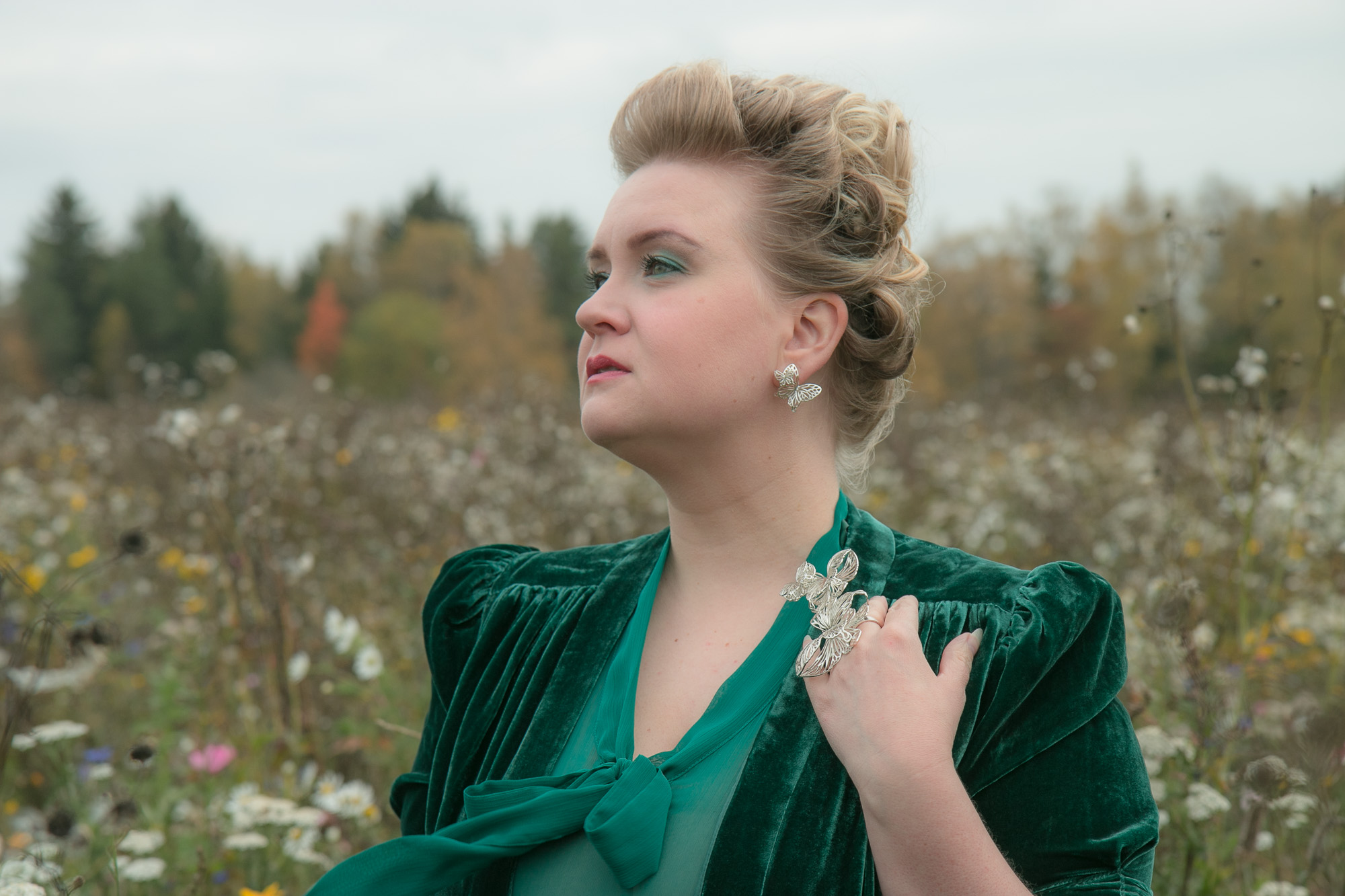 Hopeiset Jenni Rutosen korut, vihreä iltapuku, tuulenvire ja syksyinen kukkaniitty