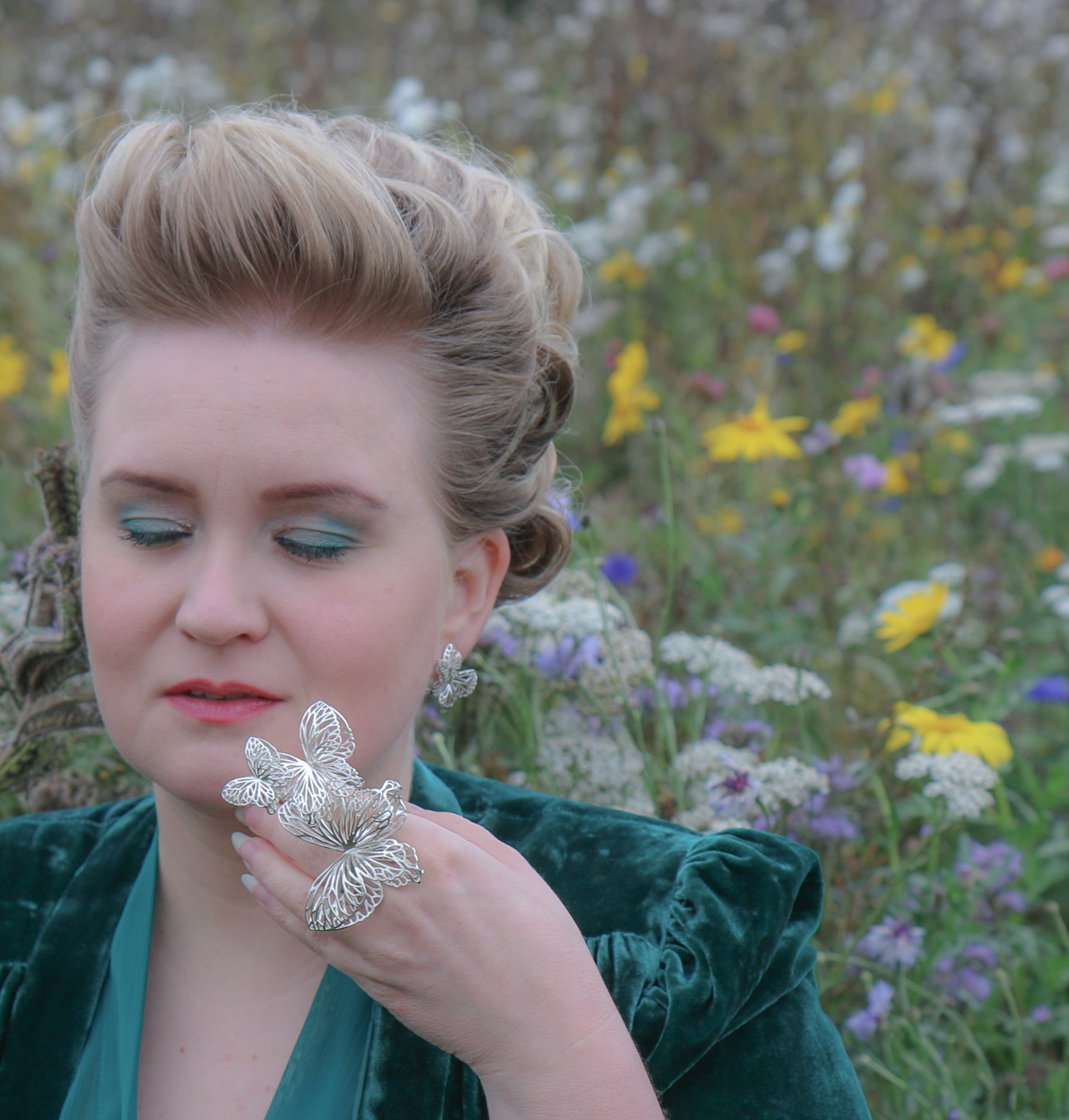 Hopeinen iso perhossormus kukkaniityllä kuvattuna. 